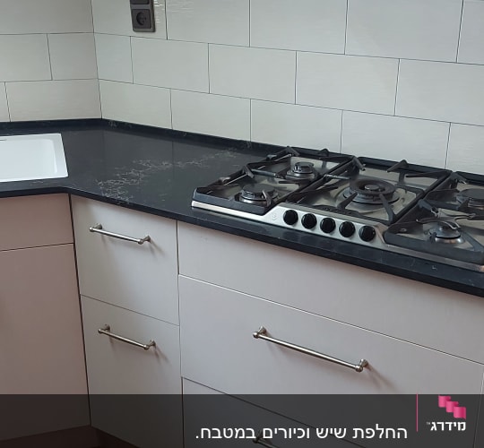 משטח שיש כהה עם כיור וכיריים